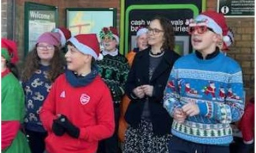 Children singing carols outside the train station